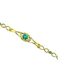 14K yellow gold bracelet with a central oval emerald and small round emerald accents.