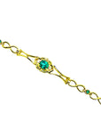 14K yellow gold bracelet with a central oval emerald and small round emerald accents.