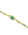 14K yellow gold bracelet with a central oval emerald and small round emerald accents.