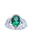 This oval-cut emerald, elegantly set at the heart of a four-leaf clover design framed by a halo of diamonds is in 14K gold.