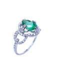 A 14k white gold ring with an oval cut emerald and diamond accents on a white background.
