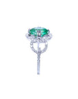 1.55 ct. oval emerald clover ring with diamond halo in 14K white gold.