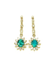Oval emerald dangle earrings with halo diamonds in 14K yellow gold.