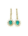 Oval emerald dangle earrings with halo diamonds in 14K yellow gold.