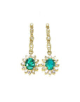Oval emerald dangle earrings with halo diamonds in 14K yellow gold.