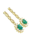 A pair of a 14k yellow gold with natural colombian emerald earrings with a halo diamond.