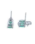 Oval cut natural emerald earrings in 14K white gold with diamond accents.