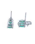 Oval cut natural emerald earrings in 14K white gold with diamond accents.