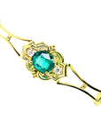 14K yellow gold bracelet with a central oval-cut natural emerald and two small round diamonds.