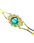 14K yellow gold bracelet with a central oval-cut natural emerald and two small round diamonds.