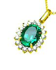 A 18k yellow gold pendant necklace with an oval cut natural emerald encircled in a halo diamond topside view.
