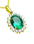 A 18k yellow gold pendant with an oval cut natural colombian emerald with a halo diamond, topside view.