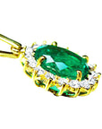 The underside gallery view of a gold emerald pendant oval cut with diamonds.