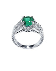 Natural oval emerald ring in 18K white gold with a decorative, bridal-style diamond band.