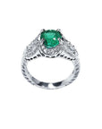 Natural oval emerald ring in 18K white gold with a decorative, bridal-style diamond band.