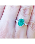 14K white gold halo ring with a 2.02 ct. oval-cut deep green emerald and natural diamonds.