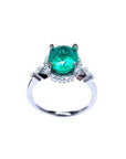 14K white gold halo ring with a deep green oval-cut emerald and sparkling diamond accents.