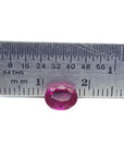 1.31 ct. oval-cut natural Burma ruby gemstone with vivid red hue, measured by a ruler.