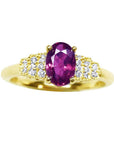 14k yellow gold ring with a sparkling deep red oval ruby and diamond accents.
