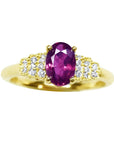 14k yellow gold ring with a sparkling deep red oval ruby and diamond accents.