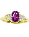 14k yellow gold ring with a sparkling deep red oval ruby and diamond accents.