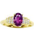 14k yellow gold ring with a sparkling deep red oval ruby and diamond accents.