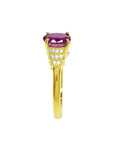 14k yellow gold ring with a deep red oval cut ruby and sparkling side diamonds.