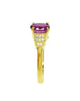 14k yellow gold ring with a deep red oval cut ruby and sparkling side diamonds.