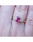 Women's 14k yellow gold ring with a deep red oval ruby and sparkling side diamonds.