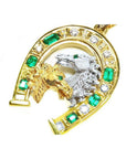 18K yellow gold horseshoe pendant with emeralds, diamonds, and two horse heads.