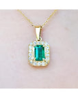 0.75 ct. GIA certified F1 Colombian emerald pendant with diamond halo in 18k yellow gold.