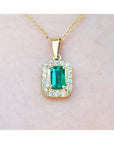0.75 ct. GIA certified F1 Colombian emerald pendant with diamond halo in 18k yellow gold.