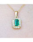 0.75 ct. GIA certified F1 Colombian emerald pendant with diamond halo in 18k yellow gold.