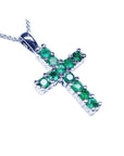 A 18k white gold cross pendant with round cut natural Colombian emeralds.