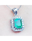 A natural colombian emerald gemstone pendant with a 14k white gold and diamonds frame.