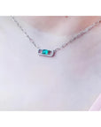 0.68 ct paper clip emerald necklace with diamonds in 18K white gold on a woman's neck.