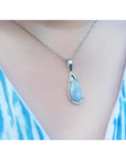 Pear-shaped Australian opal pendant with halo diamonds on an 18K white gold chain, worn on a person.