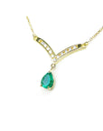 14k yellow gold pear cut emerald necklace Muzo Colombian gem is dangling from a channel set diamonds chevron design