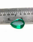 1.74-carat pear-cut Colombian emerald, vibrant deep bluish-green, shown next to a ruler.