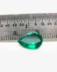 1.74-carat pear-cut Colombian emerald, vibrant deep bluish-green, shown next to a ruler.