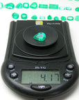 pear cut natural Colombian emerald Muzo mine, on a scale for weight display
