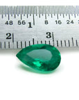 1.84 carat pear-cut natural Muzo Colombian emerald, vibrant bluish-green, shown with a ruler for scale.