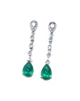 Pair of emerald teardrop earrings with diamond accent on a front position top view