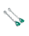 14K white gold drop earrings with brilliant diamonds and pear-shaped green emeralds.