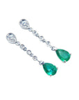 A pair of pear shaped natural colombian emerald drop earrings accent diamonds crafted in 14k white gold.