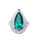 An emerald ring, pear shaped held by three prong set, encircled by double halo diamond, in 14k white gold.