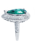 A pear shaped emerald and double halo diamond ring, in side profile position.