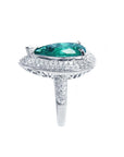 A pear shaped emerald and double halo diamond ring, in side profile position.