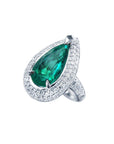 An emerald ring, pear shaped green gemstone encircled by double halo diamond, top and right side profile view.