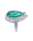 Pear-shaped 3.35 ct. emerald engagement ring in 14K white gold with diamond halo and pavé band.
